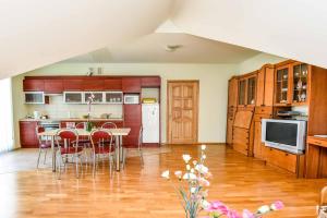 a kitchen with wooden cabinets and a table and chairs at Pas Bani in Palanga
