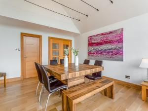Un comedor con mesa y sillas de madera. en Corrie Burn Villa, en Ullapool