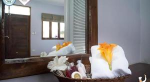 Una cesta de toallas y cosméticos frente a un espejo. en Baan Home Resort, en Kalasin 55 fotos más