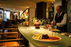 een man aan een toonbank met een bord eten bij Ritz Lagoa da Anta Hotel & SPA in Maceió