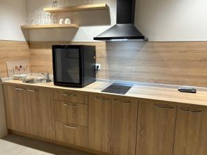 a kitchen counter with a microwave and a sink at Camellia apartments in Lepenica