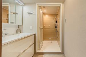 un bagno con doccia, lavandino e specchio di 365Ueno a Tokyo Altre 65 foto