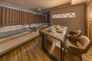 a bedroom with a bed and a table and chairs at 365Ueno in Tokyo