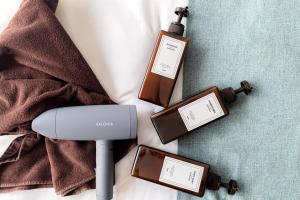 a bottle of soap and a hair dryer next to a towel at 365Ueno in Tokyo