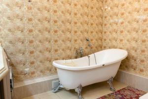 a white tub in a bathroom with a tiled wall at Mega tower 8 in Almaty
