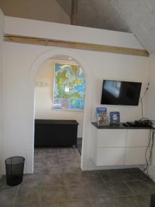 een kamer met een muur, een tv en een raam bij Hedelodden Apartment in Uve