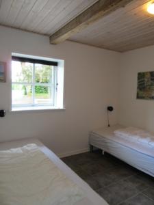 een slaapkamer met twee bedden en een raam bij Hedelodden Apartment in Uve