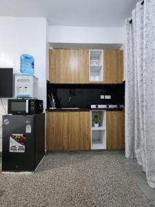 a kitchen with a refrigerator and a microwave at TVHStays premium apartments in Nairobi
