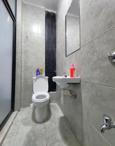 a bathroom with a white toilet and a sink at TVHStays premium apartments in Nairobi