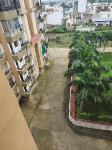 een lege straat tussen gebouwen met een palmboom bij apartment in Jabalpur 