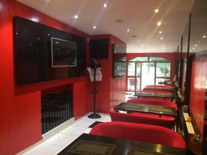 a room with red walls and red chairs and a flat screen tv at Byblov Rooms Boutique in Bucharest