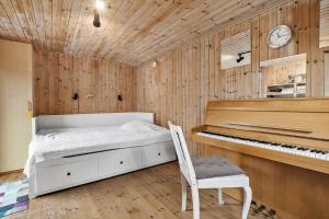 a bedroom with a bed and a piano at 1552-Liseleje-Anna-Bergenholzvej-7 in Liseleje