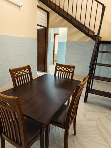 a dining room with a wooden table and chairs at Econo Homestay in Ipoh