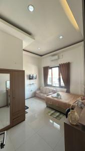 Un dormitorio grande con una cama y un sofá. en Grand Valora Anggrek Simpang Lima Semarang, en Semarang