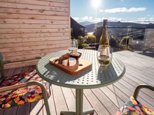 a table with a bottle of wine and two glasses at Pinot's Pod in Akaroa +3 photos