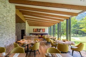 a restaurant with wooden tables and yellow chairs at Holiday Inn Resort Shinano-Omachi Kuroyon by IHG in Omachi
