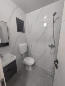 Yuvalにあるבקתה על הנחלのトイレと洗面台を備えた白いバスルーム