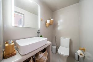Un baño blanco con lavabo e inodoro. en Earthy House - 2, en Mesariá