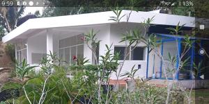 a white house with a blue door and some plants at My Dream Home Sri Lanka in Weligama