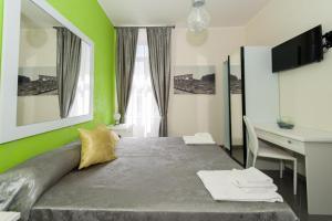 a bedroom with a bed with green walls and a desk at Il Postiglione Hotel - Sala Ricevimenti Minturno in Minturno +128 photos