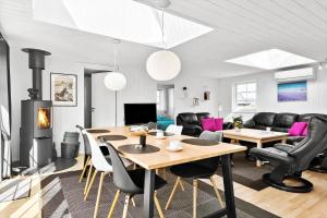 BL856-Blokhus-Soren-Tjenersvej-2 في بلوكهوس: غرفة معيشة بها طاولة وكراسي