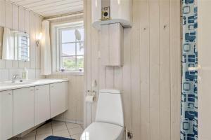 BL856-Blokhus-Soren-Tjenersvej-2 في بلوكهوس: حمام مع مرحاض ومغسلة ونافذة +16 صورة