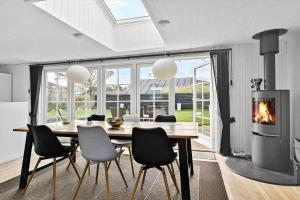 BL856-Blokhus-Soren-Tjenersvej-2 في بلوكهوس: غرفة طعام مع طاولة ومدفأة