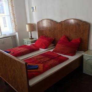 2 Betten mit roten Kissen in einem Schlafzimmer in der Unterkunft Gasthof Zur Goldenen Sonne in Passau