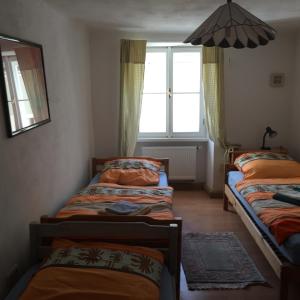 a room with three beds and a window at Gasthof Zur Goldenen Sonne in Passau