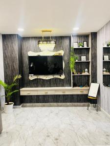 een woonkamer met een grote tv aan de muur bij The Scenic Roofhouse by Amrove near Rajpur road in Dehradun