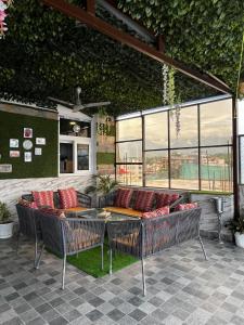 een patio met 2 stoelen en een tafel met rode kussens bij The Scenic Roofhouse by Amrove near Rajpur road in Dehradun