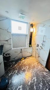 een badkamer met een vloer die bedekt is met water bij The Scenic Roofhouse by Amrove near Rajpur road in Dehradun