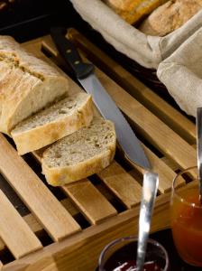a tray with slices of bread on a cutting board with a knife at Campanile Salon-De-Provence in Salon-de-Provence