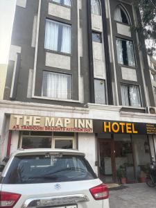 Jāmbにある1MAP INN HOTEL ZIRAKPuRのホテルの前に駐車された白い車