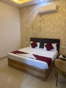 Jāmbにある1MAP INN HOTEL ZIRAKPuRのベッドルーム1室(大型ベッド1台、赤い枕付) +6枚の写真