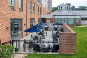 a patio with tables and chairs with umbrellas at Homewood Suites by Hilton Baltimore - Arundel Mills in Hanover