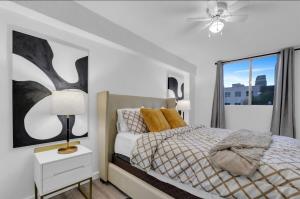 カルガリーにある17th Ave Cozy Nest in Downtown Calgary with Parkingの白いベッドルーム(ベッド1台、天井ファン付)