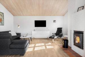 un soggiorno con divano e camino di BL1284-Blokhus-Tyttebaervej-4 a Blokhus