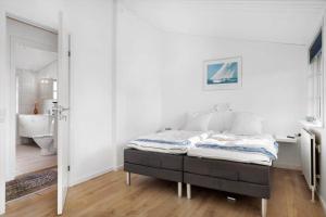 una camera da letto con un letto e un bagno di BL1284-Blokhus-Tyttebaervej-4 a Blokhus
