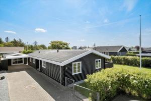 una casa nera con un tetto di BL1284-Blokhus-Tyttebaervej-4 a Blokhus