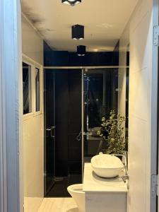 a bathroom with a sink and a glass shower at Hoshi DaLat Full House in Xuan An