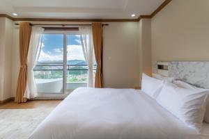 a bedroom with a large white bed and a large window at Hotel Mystic Mountain, Pokhara in Pokhara +52 photos