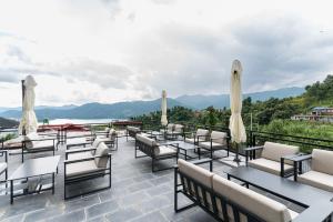 a row of chairs and tables on a patio with a view at Hotel Mystic Mountain, Pokhara in Pokhara