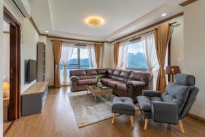a living room with a couch and chairs and a tv at Hotel Mystic Mountain, Pokhara in Pokhara