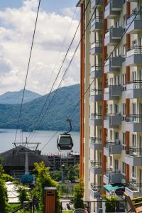 Un edificio de apartamentos con una góndola frente a un lago. en Hotel Mystic Mountain, Pokhara, en Pokhara