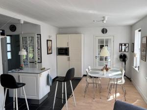 a kitchen and dining room with a table and chairs at Beautiful house with a charming garden in Brønderslev