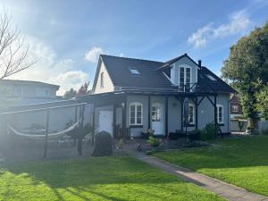 a white house with a glass extension to a yard at Beautiful house with a charming garden in Brønderslev