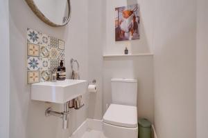 a bathroom with a white toilet and a sink at Quaint converted stables in Carlby in Carlby +6 photos