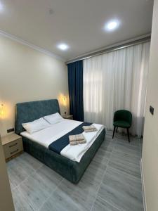 a bedroom with a large bed and a chair at Hotel Moon in Samarkand