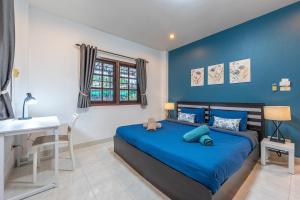 Dormitorio azul con cama y escritorio en Serenity Holiday Villa 1 D Karon Beach, en Karon Beach